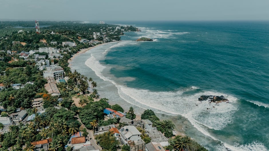 Stunning aerial view of a coastal city in Sri Lanka, showcasing lush greenery, beaches, and the ocean.