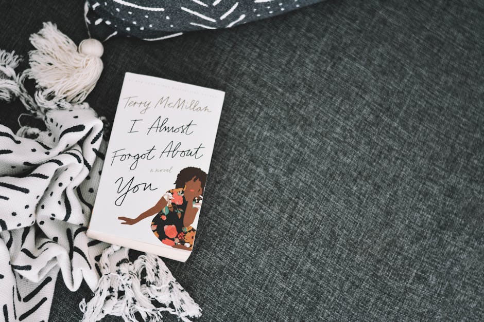 A novel by Terry McMillan on a textured fabric with decorative tassels, captured in a stylish flat lay.