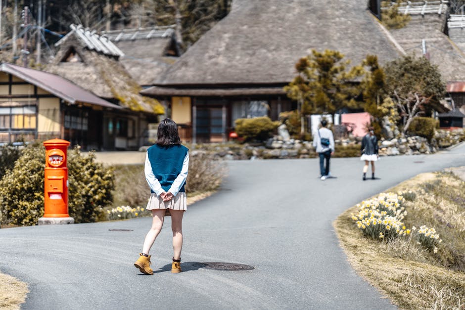Girl strolling down a scenic village street with traditional thatched-roof houses.