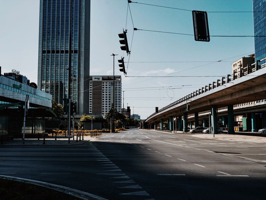 A quiet city intersection with elevated roads and tall skyscrapers captured during the day.