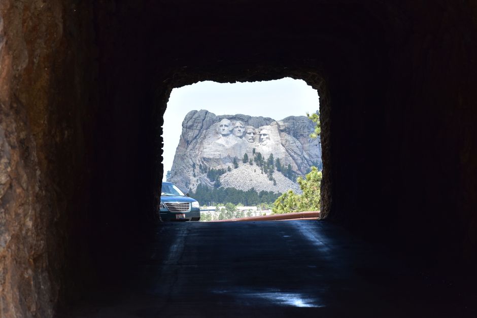 Mount Rushmore framed through a tunnel, showcasing iconic presidential sculptures in South Dakota.