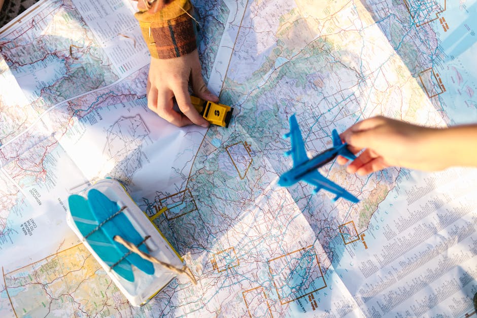 Hands holding a toy airplane and car over a map, symbolizing travel planning and exploration.