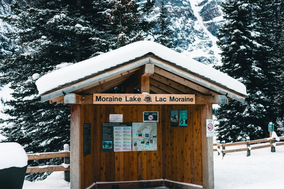 Scenic view of a wooden hut at Moraine Lake, Banff, during winter, surrounded by snow-cove