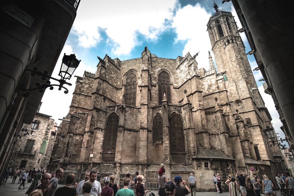 A Gothic cathedral in Barcelona with tourists exploring the historic architecture.