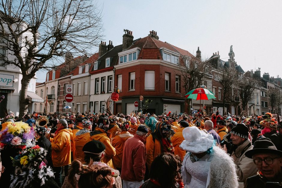 Vibrant street parade with people in colorful costumes in a European city.